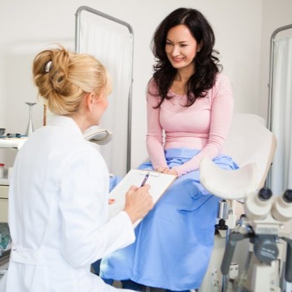 Women in exam room talking to gynecologist 